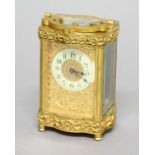 FRENCH GILT BRASS CARRIAGE TIME PIECE, the ivorine chapter ring on a scrolling gilt ground, eight