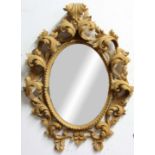 FLORENTINE STYLE CARVED LIME WOOD MIRROR, the oval plate inside a deep relief, scrolling foliate