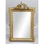 GILT GESSO WALL MIRROR, 19th century, the rectangular plate beneath a rococo crest and framed by