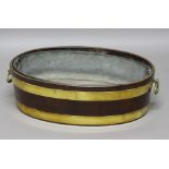 GEORGE III MAHOGANY AND BRASS BOUND WINE COOLER, of oval form with lining and brass carry handles,