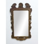 GEORGE III GILTWOOD WALL MIRROR, the rectangular plate beneath a scrolling crest centred on a shell,