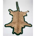 LEOPARD SKIN RUG a Leopard skin rug mounted on a material backing, some damages 247cms long. *This