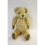 VINTAGE TEDDY BEAR with a swivel head, glass eyes and padded feet and hands. No makers label,