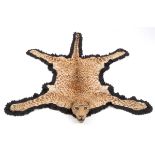 LEOPARD SKIN RUG a full mounted Leopard skin and head, mounted on a material backing. The backing