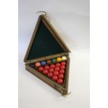 CASED SNOOKER BALLS an early 20thc oak triangular case with brass hooks (for it to be hung),