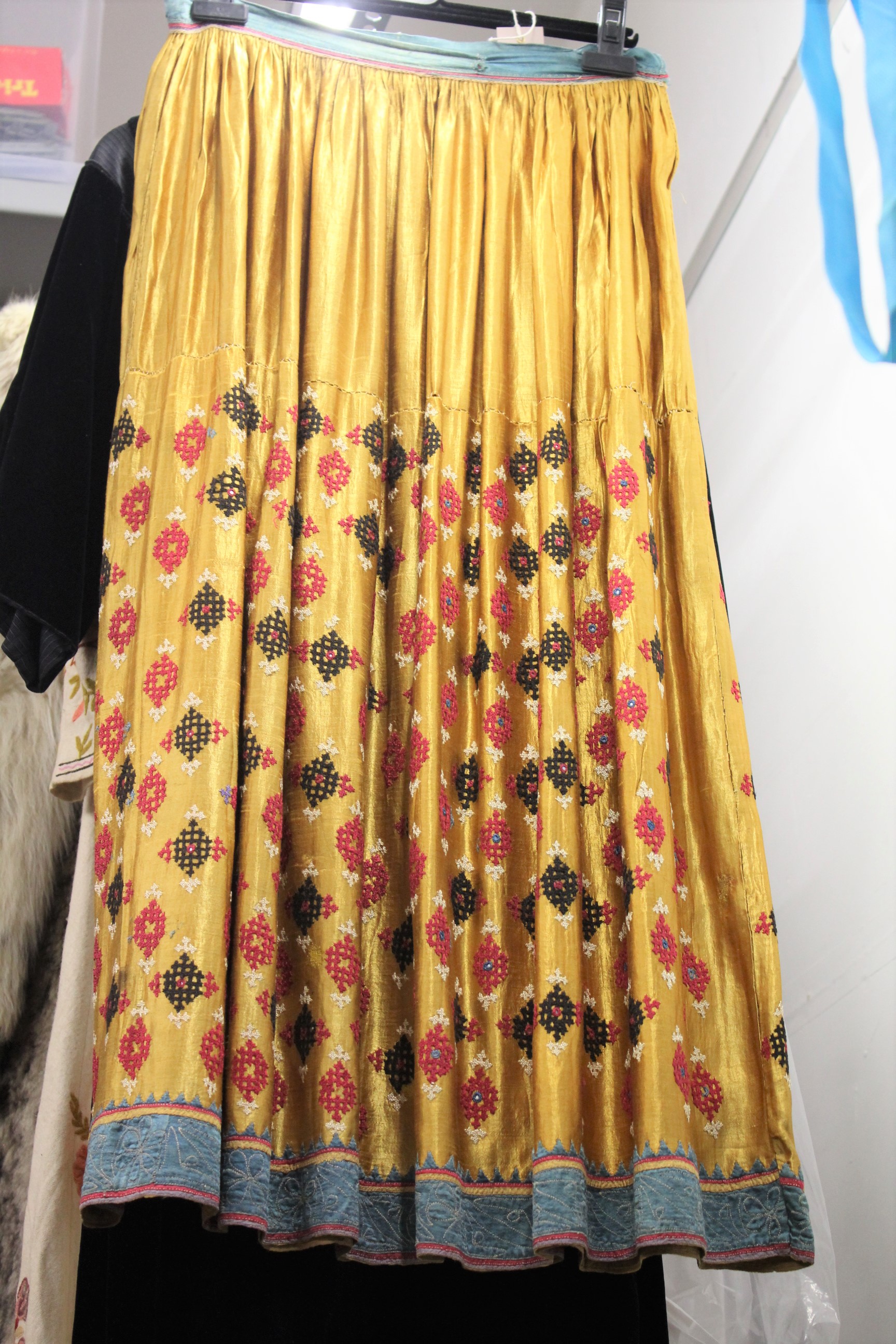 ANTIQUE INDIAN SKIRT a full length gathered skirt made from 19thc gold coloured silk, embroidered