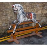 ROCKING HORSE a large painted rocking horse, fitted with a saddle and bridle and supported on a