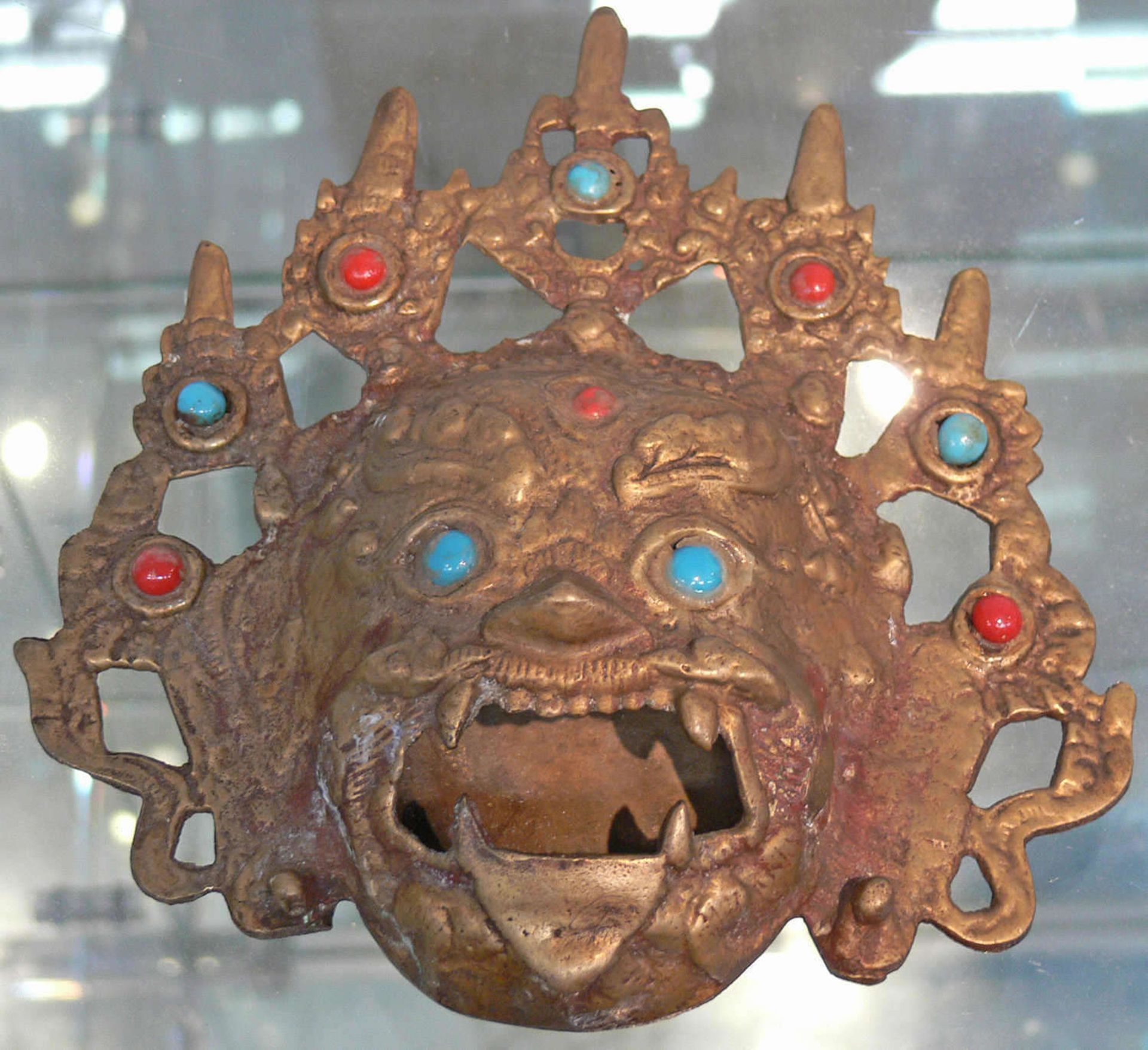 Antike tibetanische Wächtermaske, Bronze, feuervergoldet. Mit Türkisen und Korallen besetzt. Maße: