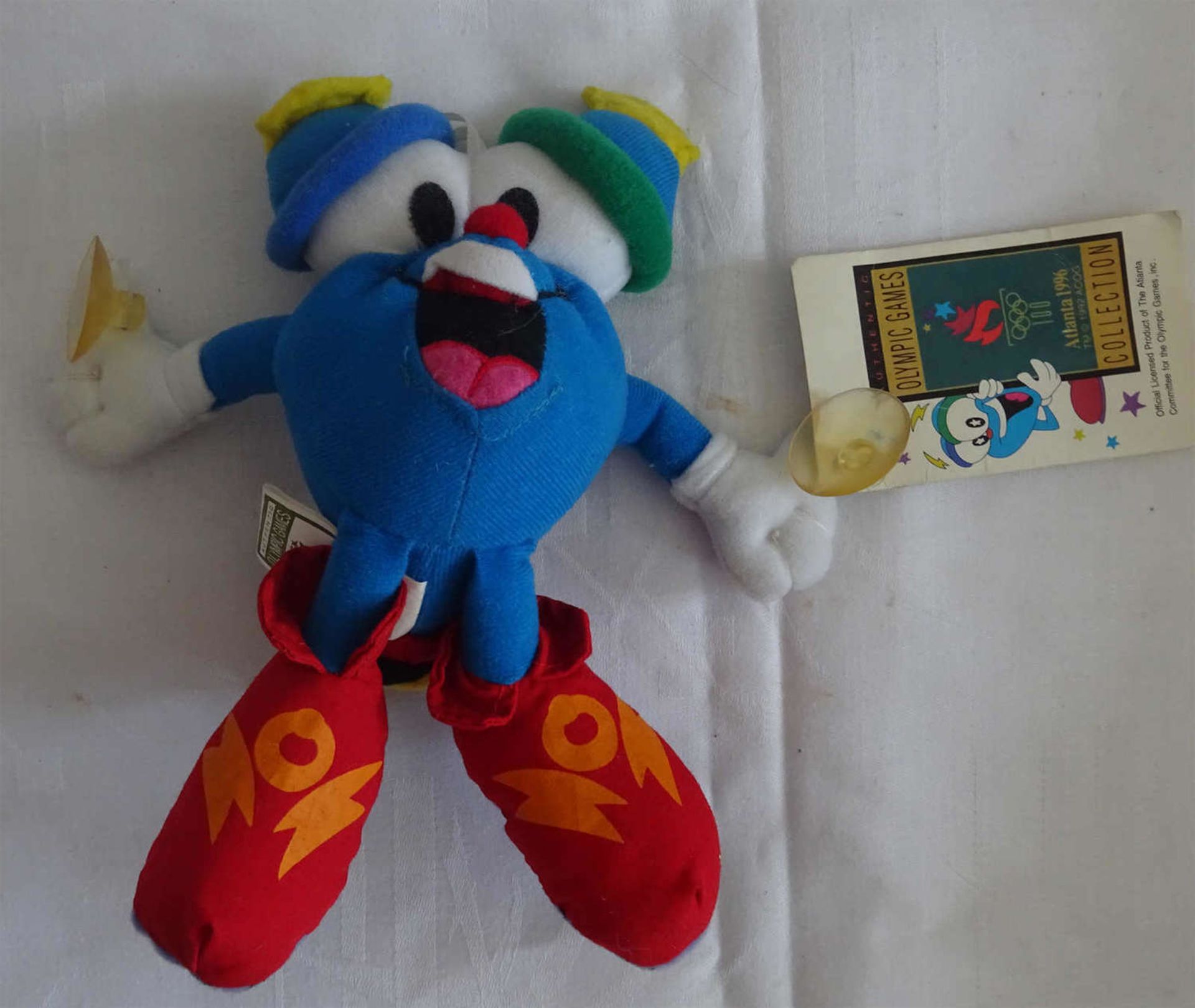 "Izzy" Maskottchen der Olympischen Spiele in Atlanta 1996. Mit Saugknöpfen. Höhe ca. 20 cm"Izzy"