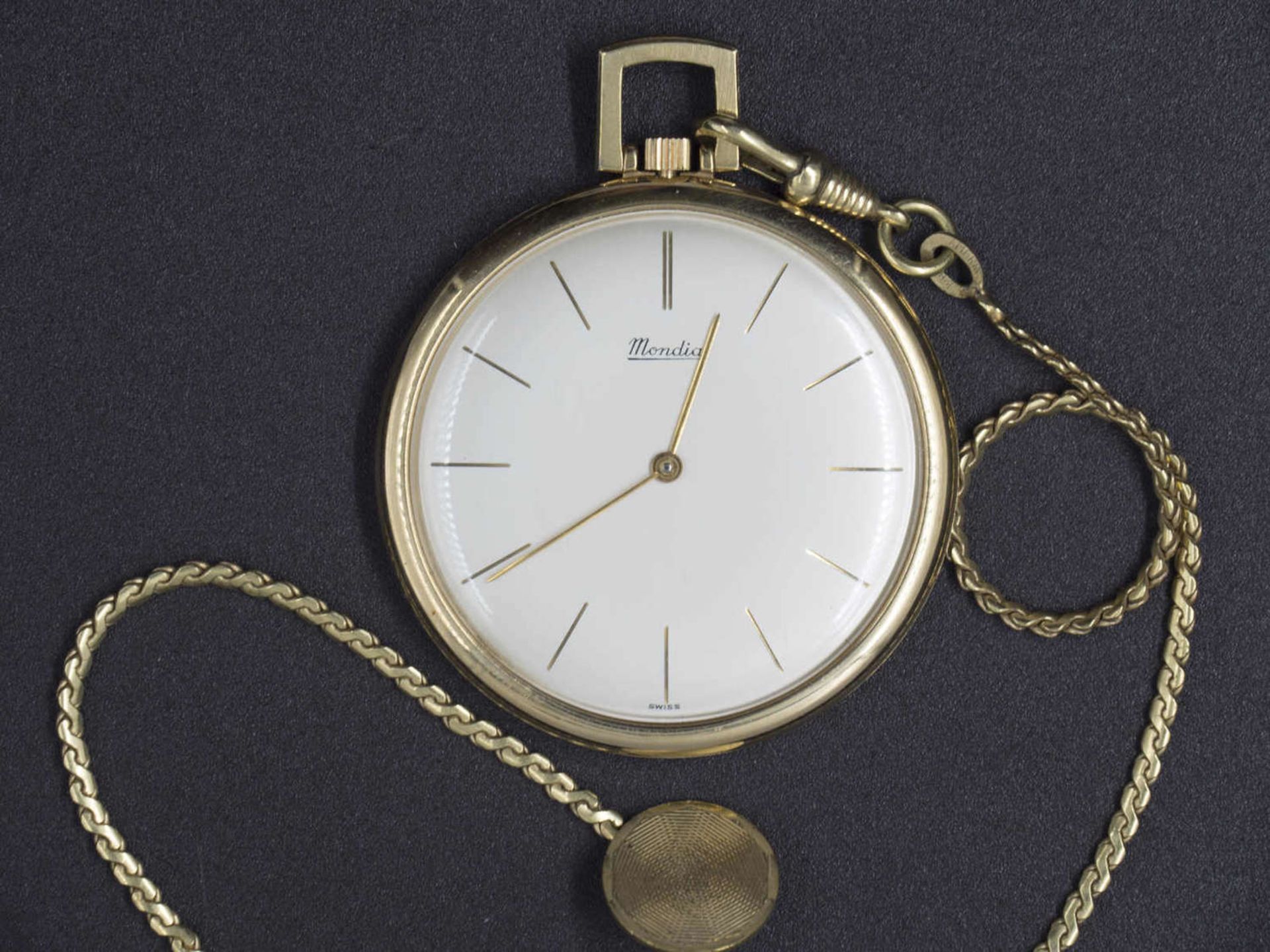 Mondia Swiss dress watch. Manual winding. Gilded. With watch chain, gilded. The clock starts.