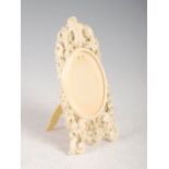 A late 19th century Dieppe ivory frame, carved with roses, foliage and scrolls, with strut