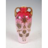 A late 19th century peach blow twin handled glass vase, with gilded foliate decoration, 14.5cm