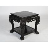A Chinese dark wood square shaped table, Qing Dynasty, the panelled square top above a frieze carved