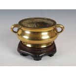 A Chinese bronze censer, Qing Dynasty, with two tapered cylindrical loop handles, with bird and