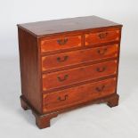 A George III mahogany and boxwood lined chest, the rectangular top inlaid with central oval patera