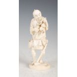 A Japanese ivory okimono of a farmer, Meiji Period, carved standing and pruning a fruiting peach