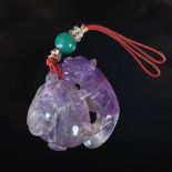 A Chinese amethyst pendant, Qing Dynasty, carved with red panda and fruit, 4cm x 4cm.