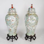 A large pair of modern Chinese porcelain famille verte style floor vases and covers on stands,