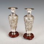 A pair of Chinese silver dragon vases, late 19th/ early 20th century, the tapered cylindrical bodies