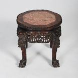 A Chinese dark wood jardiniere stand, Qing Dynasty, the shaped circular top with a mottled red