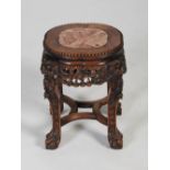 A Chinese dark wood jardiniere stand, Qing Dynasty, the shaped circular top with a mottled red