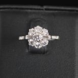 A mid 20th century diamond cluster ring, centred with a round brilliant cut diamond, estimated to