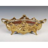 A late 19th century French Rococo style ormolu twin handled jardiniere, cast with flowers and