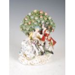 A Chelsea style porcelain figure group, modelled with male and female and dog before flowering