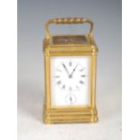 A late 19th/ early 20th century French brass repeating carriage clock with alarm, the white enamel