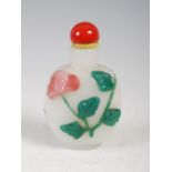 A Chinese glass two colour overlaid scent bottle, carved in relief with peony and foliage, 7.5cm