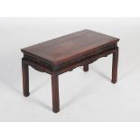 A Chinese dark wood low table, Qing Dynasty, the rectangular panelled top above a pierced and scroll