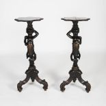 A pair of late 19th century ebonised Blackamoor torcheres, the shaped rectangular tops with