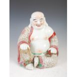 A Chinese porcelain figure of a laughing Buddha, late 19th/ early 20th century, decorated in