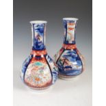 A pair of Japanese Imari bottle vases, Meiji Period, decorated with panels of long tailed birds