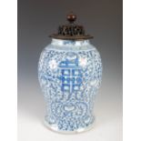 A Chinese porcelain blue and white jar and wood cover, Qing Dynasty, decorated with Shou characters,