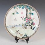 A Chinese porcelain dish, early 20th century, decorated with doves, peony and trees in a fenced