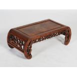 A Chinese dark wood low table, late 19th/early 20th century, the rectangular panelled top above a