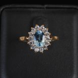 A blue topaz and cubic zirconia cluster ring, centred with an oval faceted blue topaz, calculated to