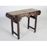A Chinese dark wood table, Qing Dynasty, the rectangular panelled top above a frieze centred with
