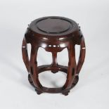 A Chinese dark wood barrel shaped stool, 20th century, the circular panelled top within a