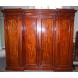 A Victorian mahogany inverted breakfront wardrobe, the moulded cornice above central pair of