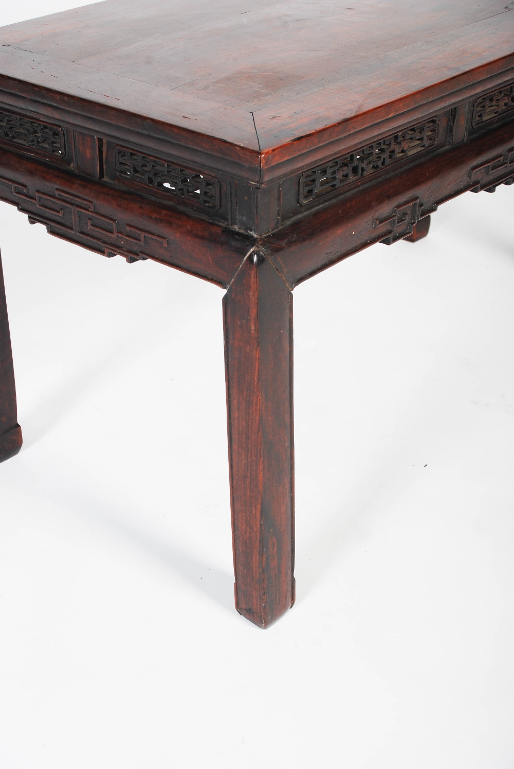 A Chinese dark wood low table, Qing Dynasty, the rectangular panelled top above a pierced and scroll - Image 2 of 5