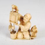 A Japanese ivory okimono of a street entertainer, Meiji Period, 7cm high x 5.5cm wide.