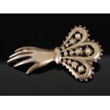 An early 20th century white metal, paste and simulated split pearl brooch in the form of a hand,