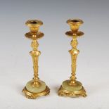 A pair of gilt metal and onyx candlesticks, the foliate cast nozzles raised on caryatid columns