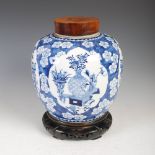 A Chinese porcelain blue and white jar, wooden cover and stand, Qing Dynasty, the jar decorated with