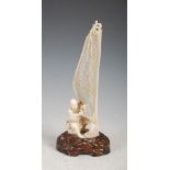 A Japanese ivory okimono of a fisherman tending net, Meiji Period, on carved wood stand, overall