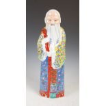 A Chinese porcelain figure of a sage, early 20th century, modelled standing wearing yellow and