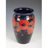 Pomegranate, a Moorcroft pottery vase, decorated with flowers and foliage on a blue ground,