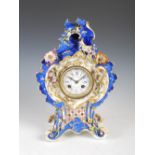 A 19th century porcelain flower encrusted mantle clock in the manner of Jacob Petit, the circular